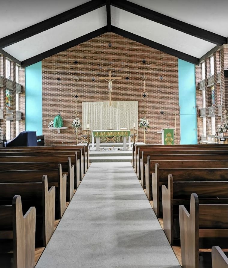 Inside St Hugh's: wooden pews either side of the aisle leading to the altar and crucifix